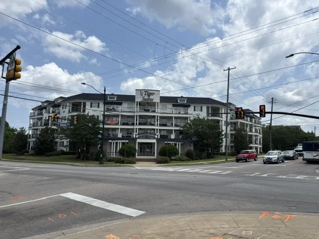 A prominent multi-story building offers street-side living with several private balconies.