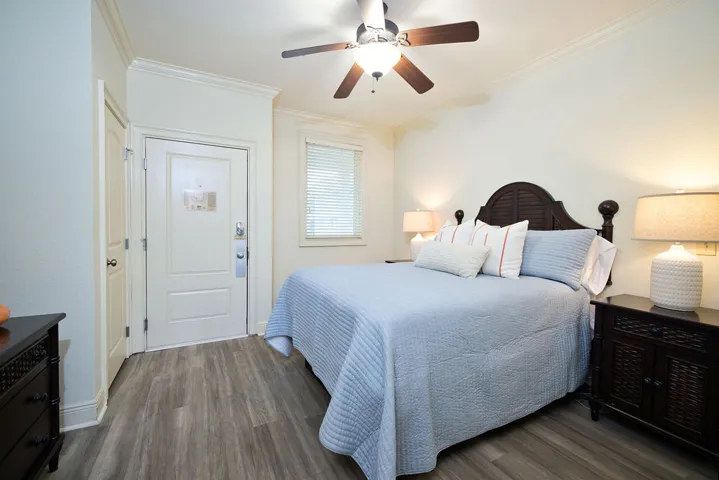 Crown molding highlights the crisp lines of this bedroom with durable wood-look flooring.