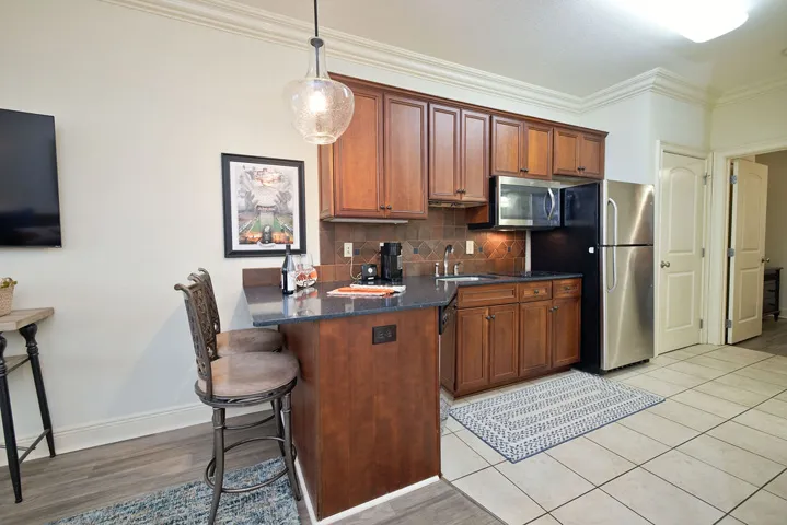 Rich wood cabinetry paired with stone countertops defines this functional kitchen space.