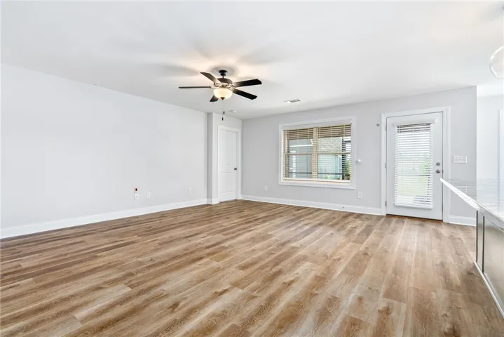 A well-lit interior space features elegant LVP flooring and a contemporary ceiling fan.