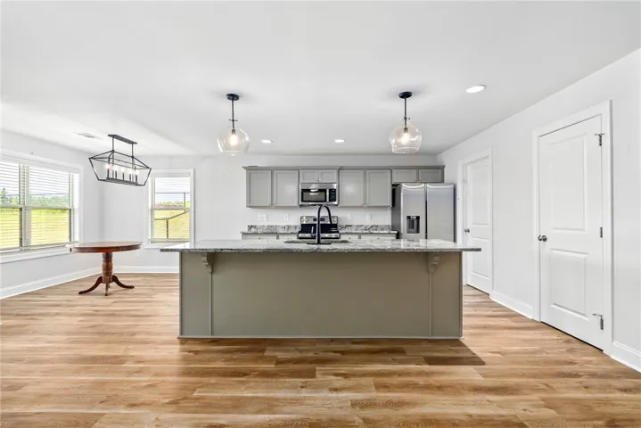 A well-lit culinary space showcases a generous island, ideal for entertaining, complemented by ample cabinetry.