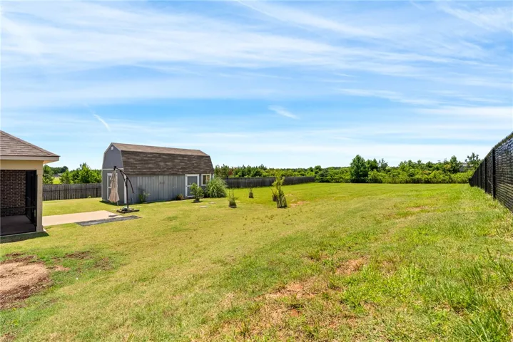 A spacious yard with a charming shed, perfect for outdoor activities and storage.