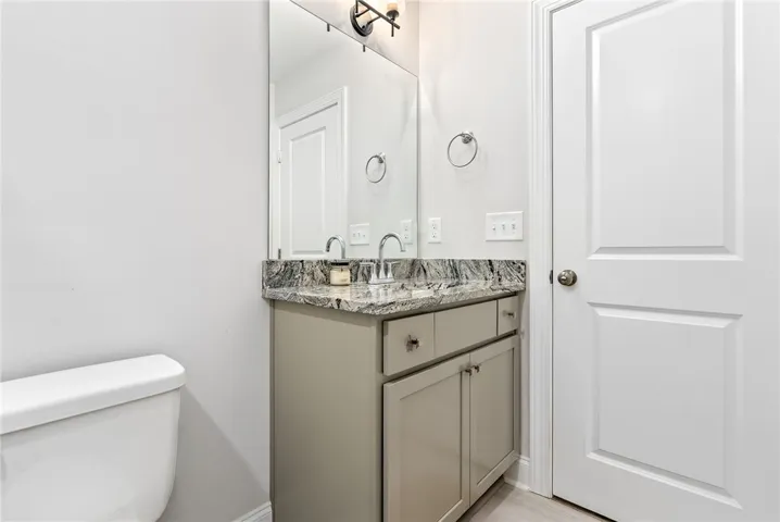 A refined bathroom features a stylish vanity with a granite countertop and contemporary fixtures.