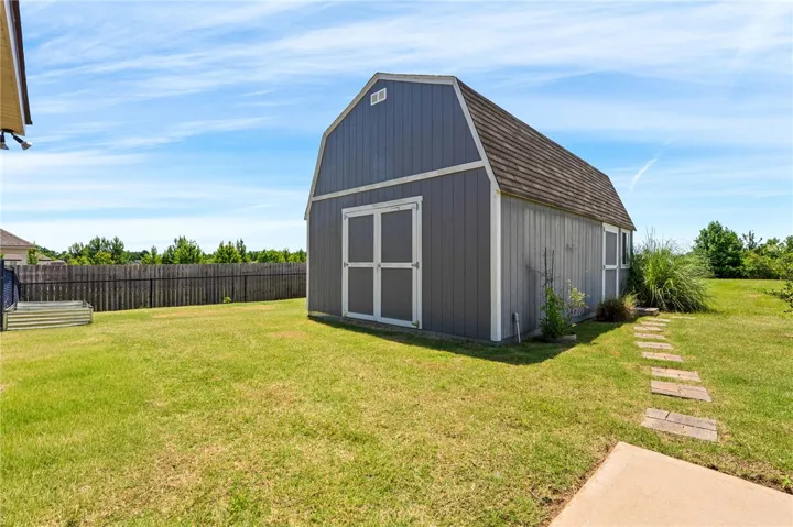 A well-maintained backyard with a charming shed and a neat lawn provides ample outdoor living space.