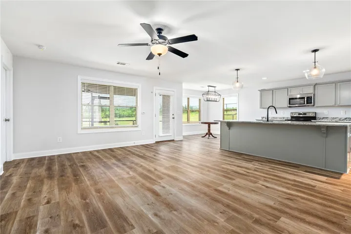 An open concept living area features abundant natural light and LVP