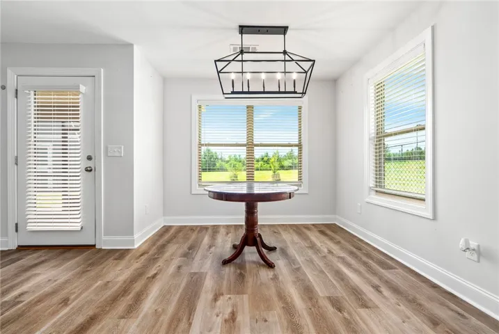 A warm, naturally illuminated dining area with stylish LVP flooring.