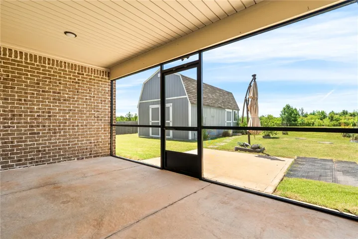 An inviting screened porch provides a tranquil connection to the generous, well-kept yard and outbuilding.