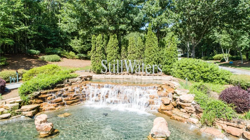 An inviting entrance with a cascading waterfall and lush greenery welcomes residents home.