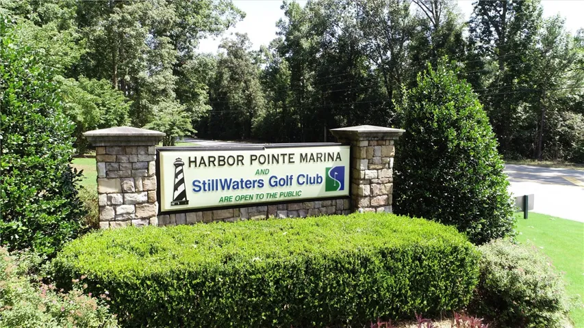 Stone pillars flank a welcoming sign, hinting at a community with recreational amenities.