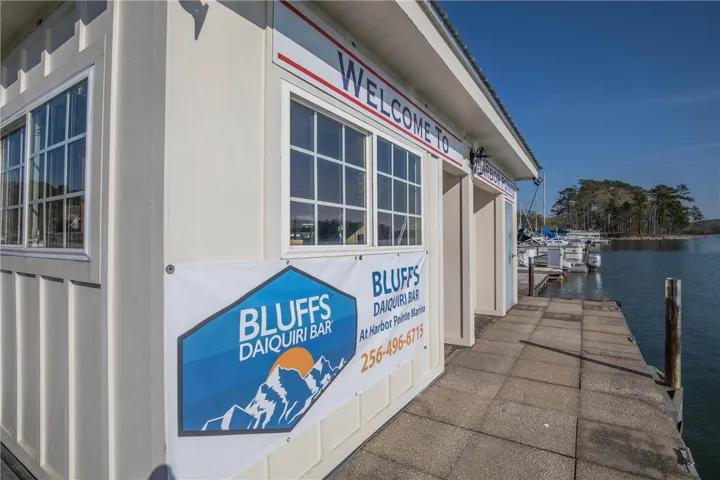 Lakeside building with ample window space sits adjacent to a bustling boat dock.