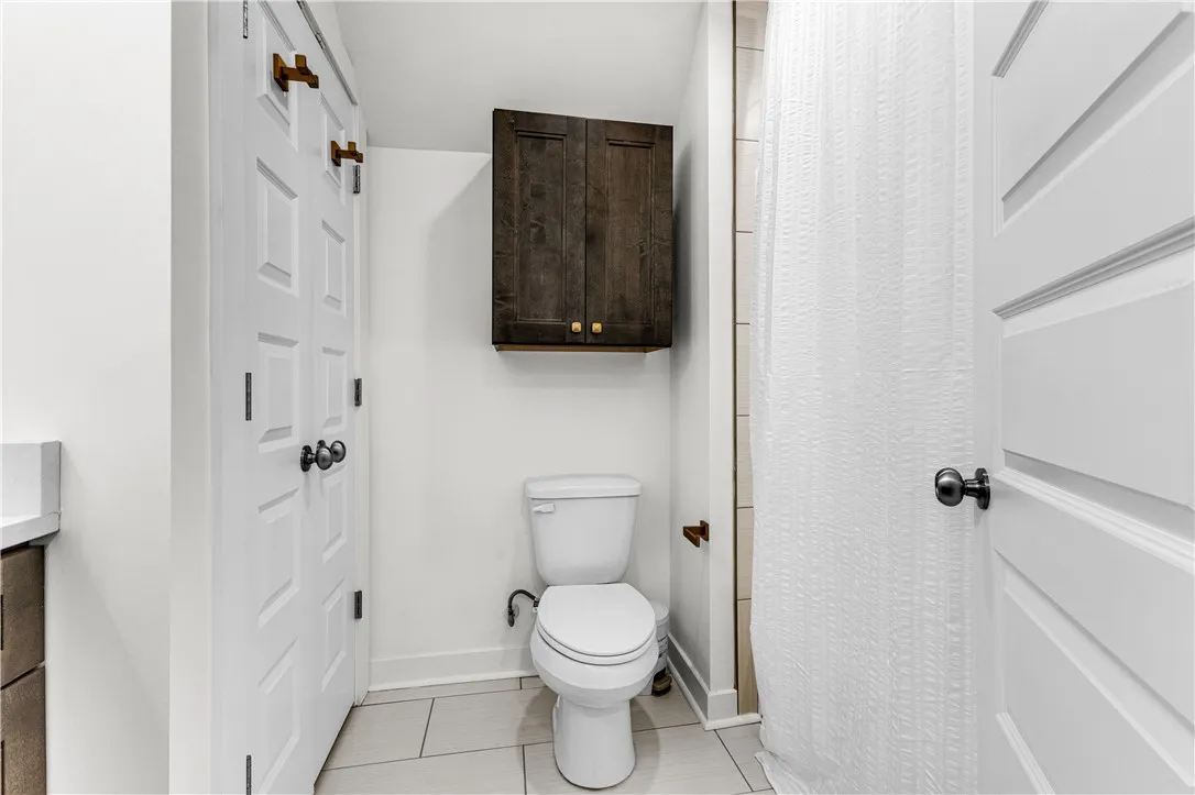 Functional full bathroom featuring bright white walls and a sleek vanity for daily routines.