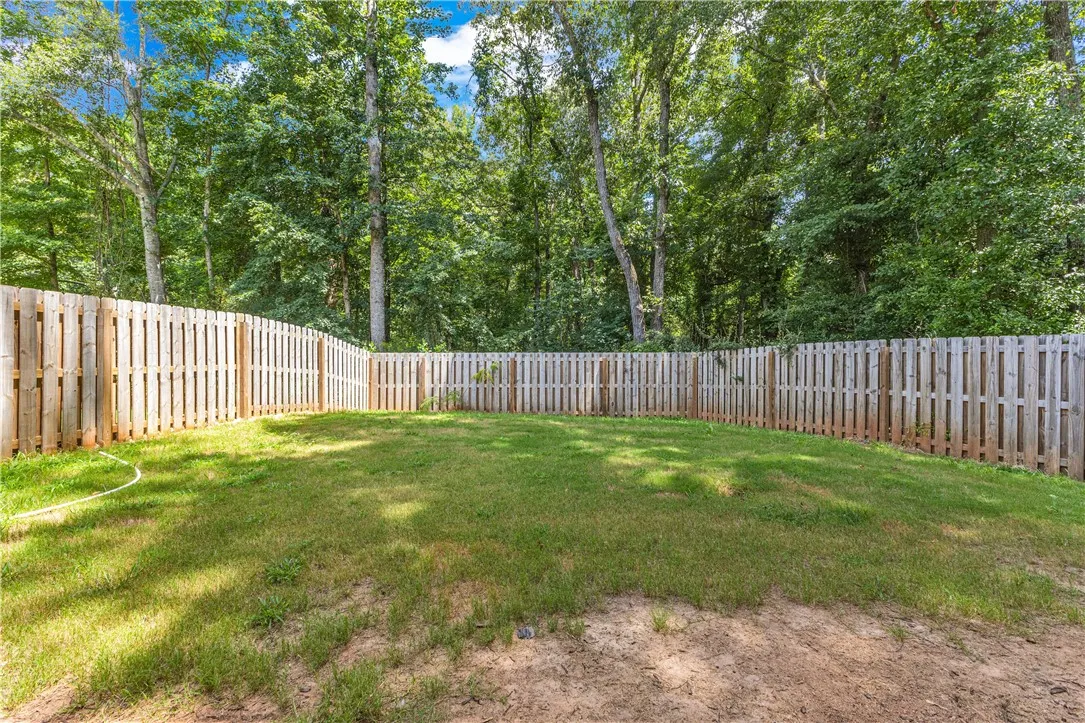 Secure yard featuring a tall privacy fence, perfect for outdoor activities and relaxation.