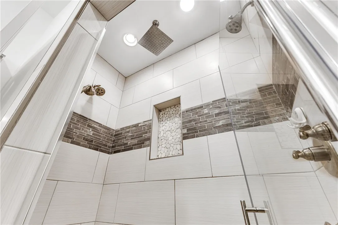 Dual shower heads and sleek tile design offer a modern bathing experience.