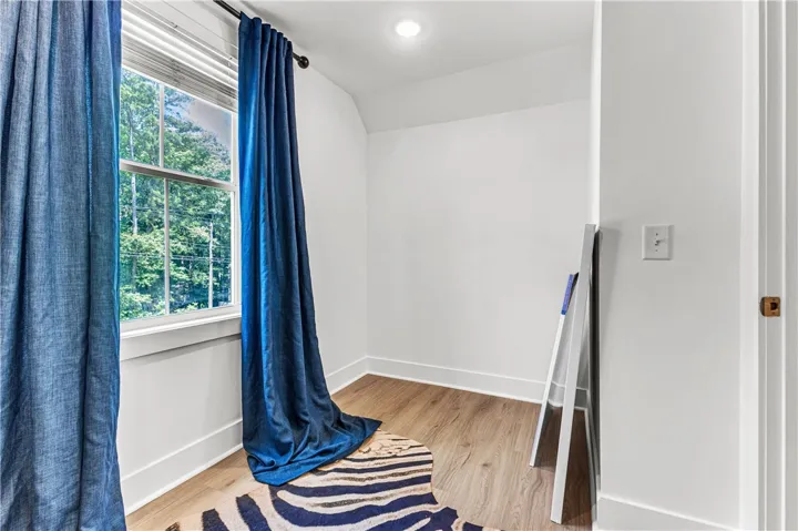 Sun-filled room featuring durable wood flooring and ample natural light, ideal for a home office.