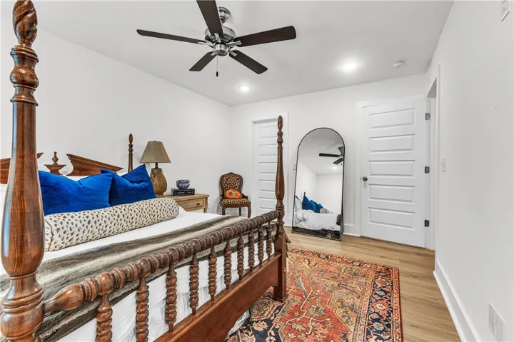 A comforting bedroom showcasing light wood flooring and a modern ceiling fan for optimal comfort.