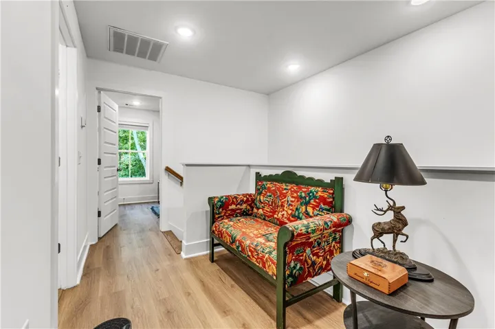 A well-lit landing features light wood flooring and a charming patterned bench.