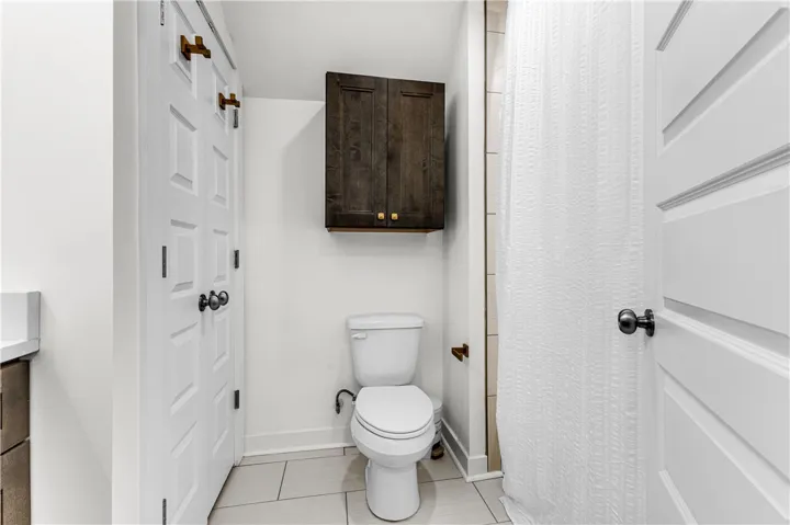 Functional full bathroom featuring bright white walls and a sleek vanity for daily routines.