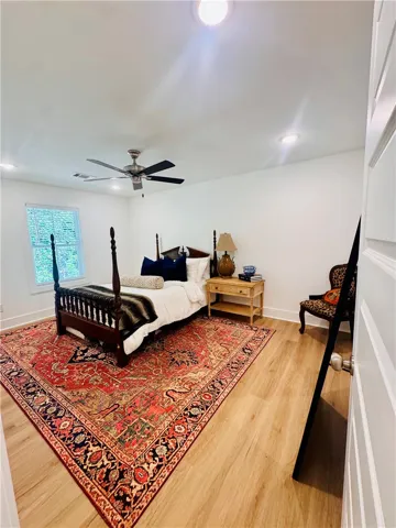 Wood flooring and recessed lighting create a comfortable, well-lit bedroom.