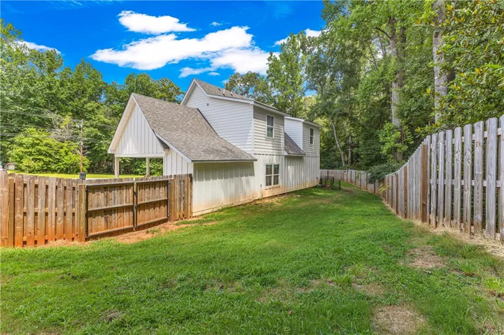 A private, fenced backyard offers verdant views and ample space for outdoor living.