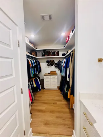 Custom built-ins and rich flooring enhance this spacious walk-in closet.