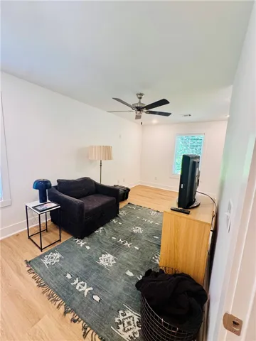 Hardwood floors and a ceiling fan create a comfortable atmosphere in this inviting room.