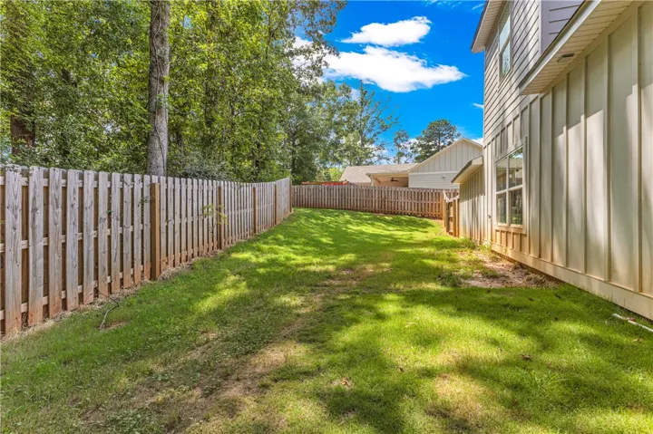 A fully fenced backyard with ample green space offers a private retreat for outdoor enjoyment.