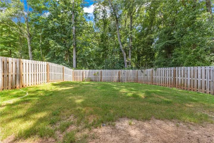 Secure yard featuring a tall privacy fence, perfect for outdoor activities and relaxation.