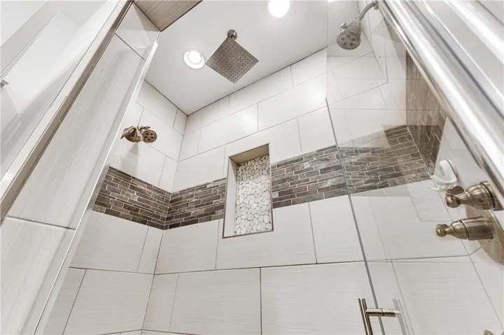 Dual shower heads and sleek tile design offer a modern bathing experience.