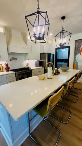 A well-appointed kitchen showcasing a spacious island with ample seating and elegant pendant lighting.