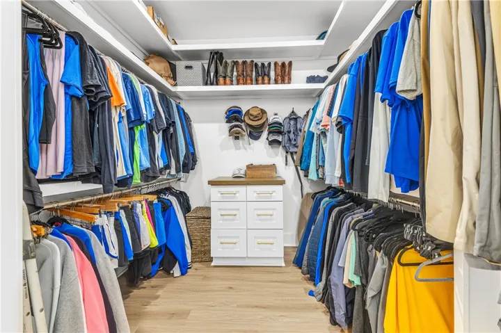 Custom shelving and hanging space in this generously sized walk-in closet offer exceptional organization.