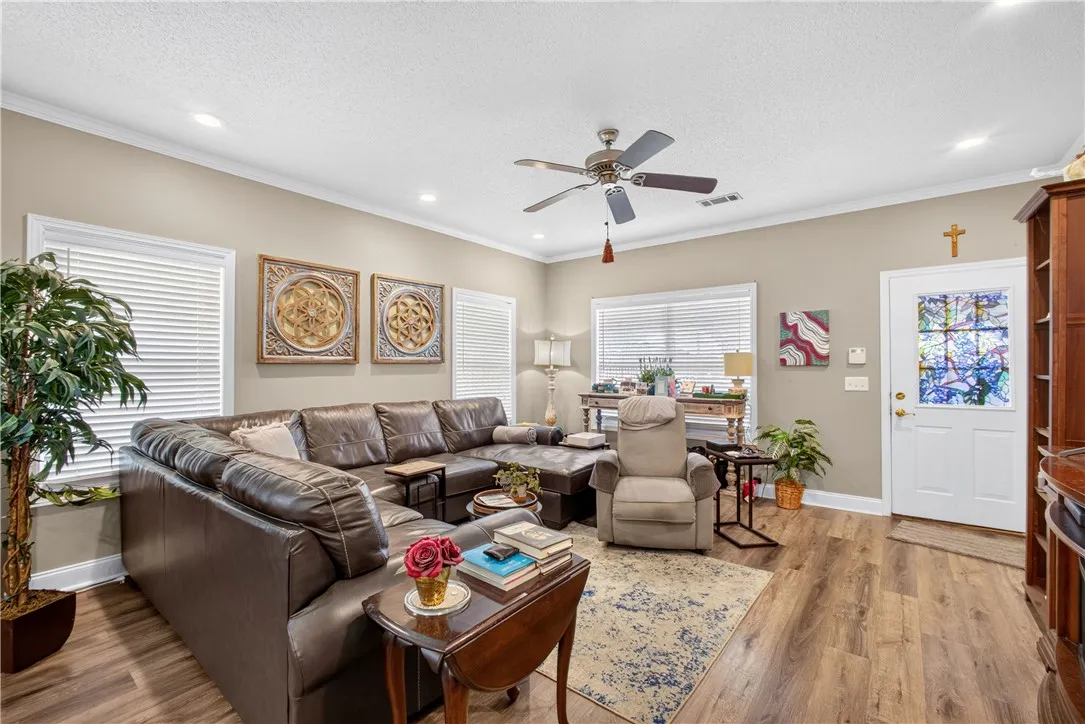 Natural light filters into this inviting living area featuring crown molding and rich hardwood flooring.