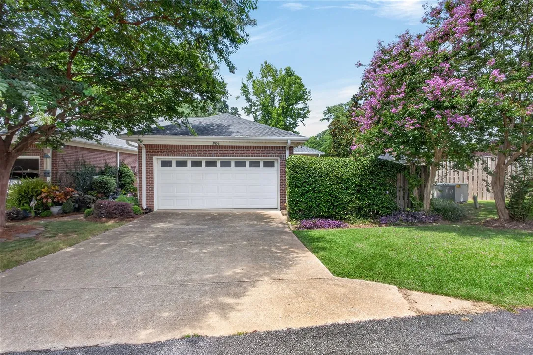 A well-maintained brick facade and an attached garage with a concrete driveway welcome you home.