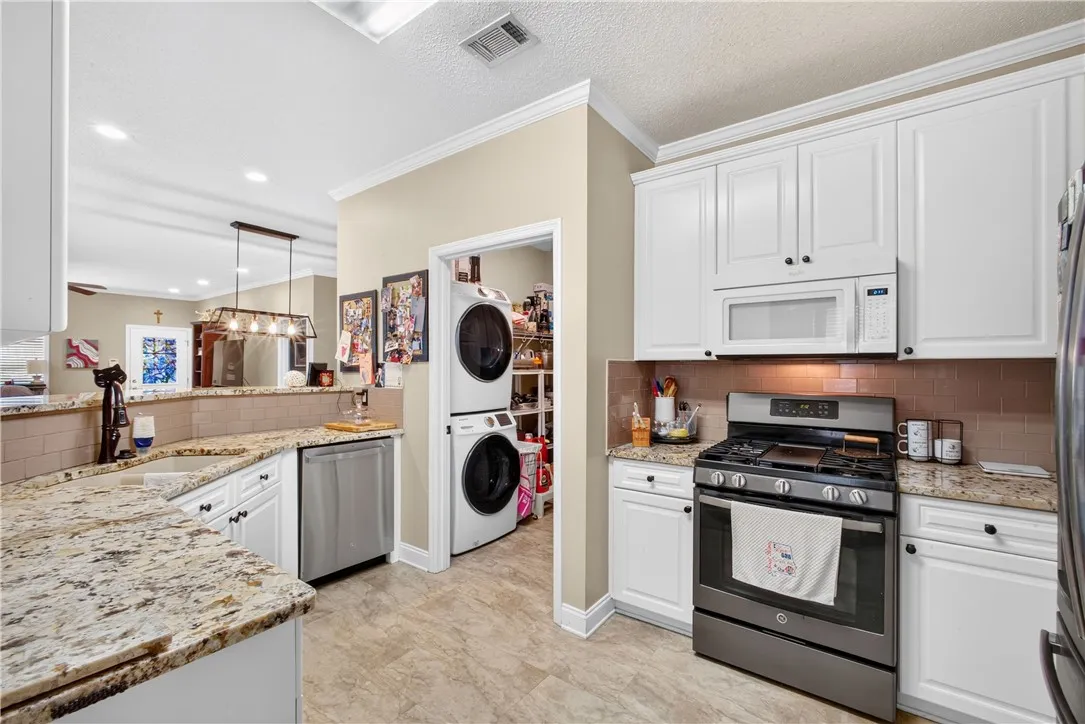 Culinary delights await in this modern kitchen with ample counter space and integrated laundry convenience.