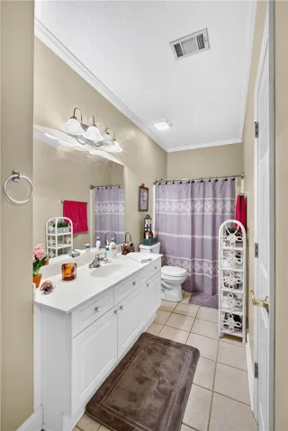 White cabinetry with ample counter space creates a functional and neat bathroom.