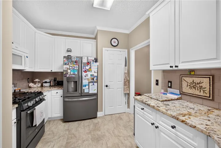 Granite counters and stainless steel appliances elevate this functional kitchen space.