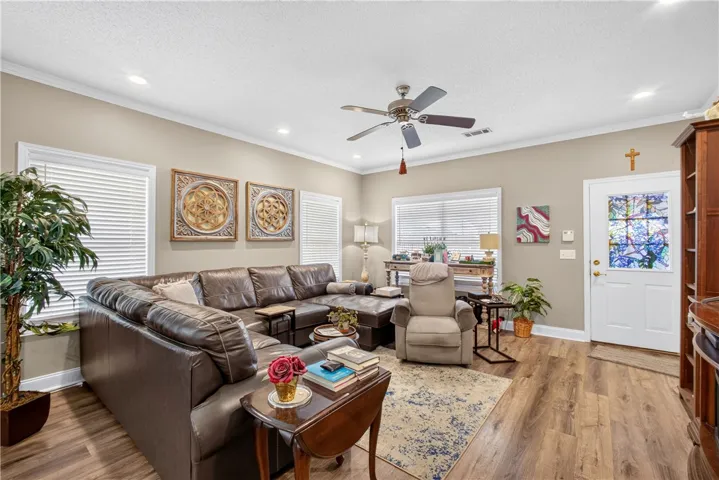 Natural light filters into this inviting living area featuring crown molding and rich hardwood flooring.