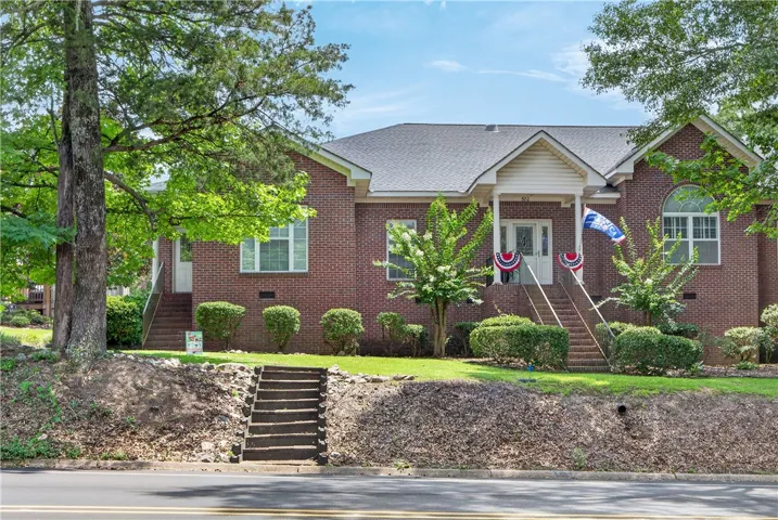A classic brick exterior, framed by mature trees, welcomes you with a charming front entrance.