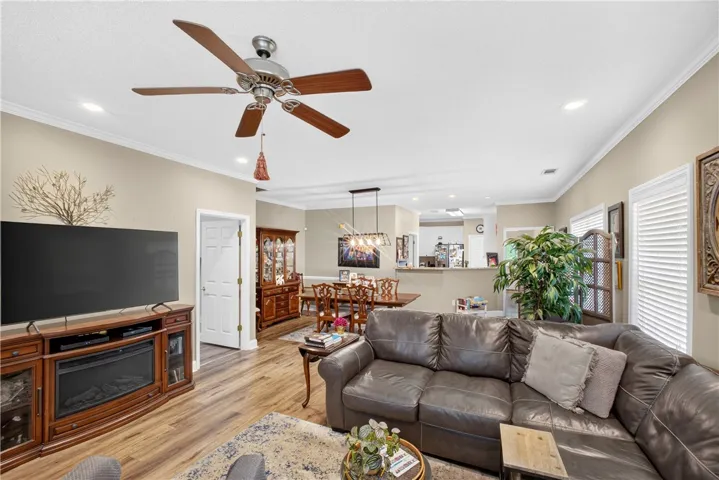 An inviting open-concept living area boasts recessed lighting and durable hardwood-style flooring, perfect for gatherings.