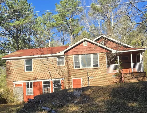 A classic brick exterior blends with natural surroundings, offering a welcoming facade.