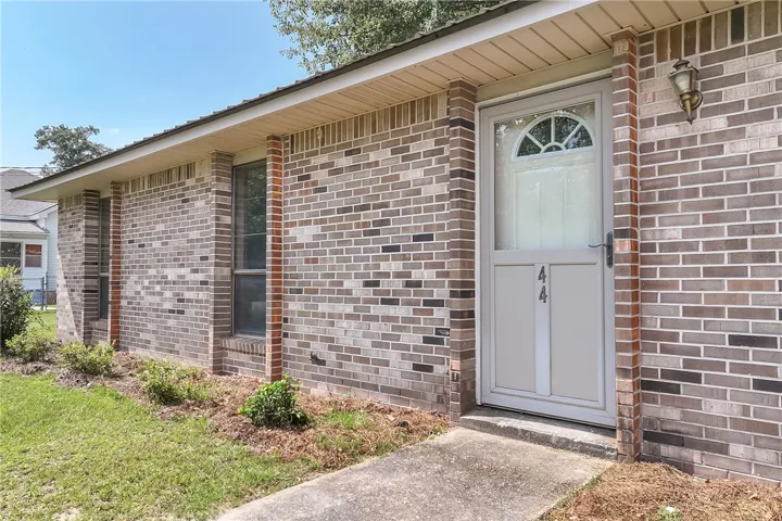 A welcoming entry, with a brick facade and a classic storm door, creates inviting curb appeal.