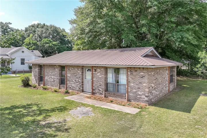 A classic brick exterior with a durable metal roof offers lasting curb appeal and low maintenance.