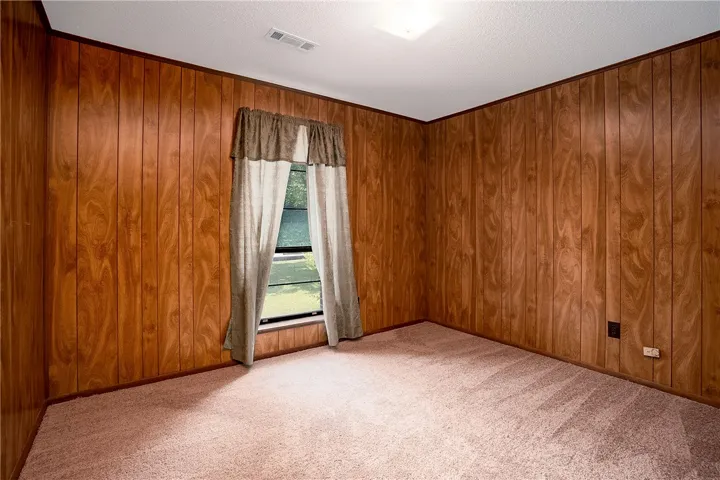 Natural wood paneling adorns the walls of this inviting, well-lit room.