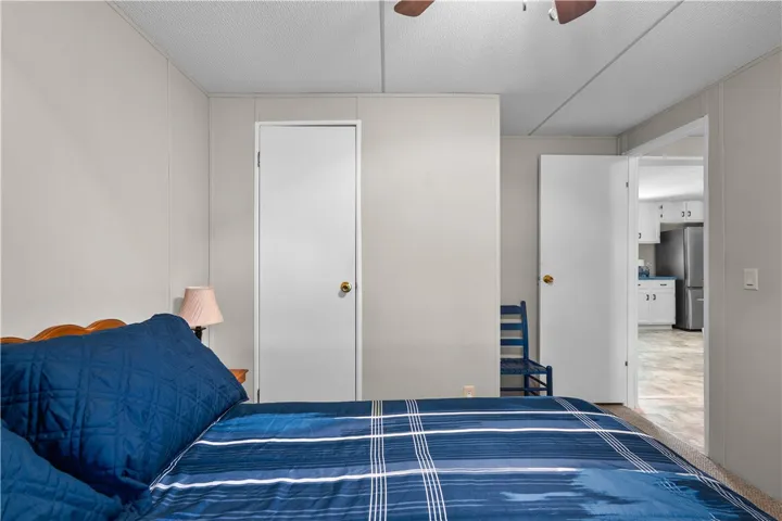 An inviting bedroom offers a glimpse into an adjacent kitchen space.