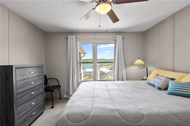 A naturally illuminated bedroom with a captivating lake view offers tranquil respite.
