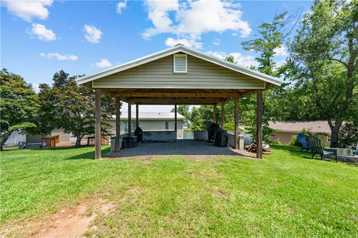 A spacious covered outdoor area perfect for gatherings, nestled amidst a verdant landscape.