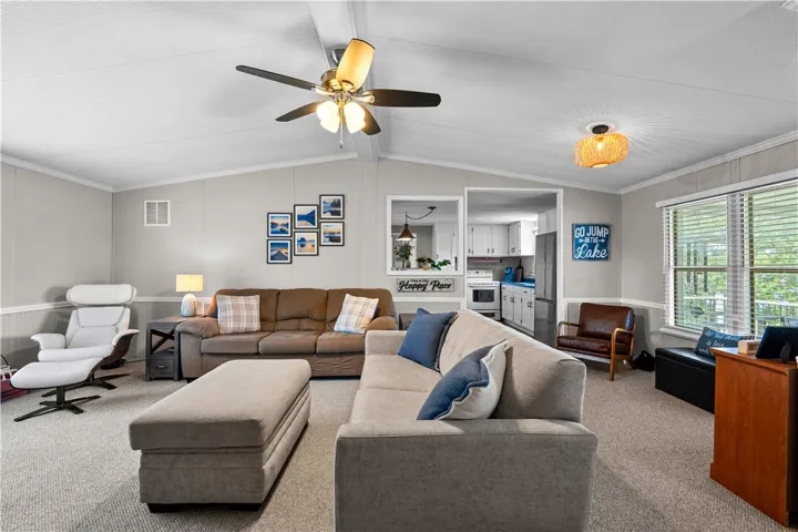 A well-lit gathering space with plush seating flows into a modern kitchen.