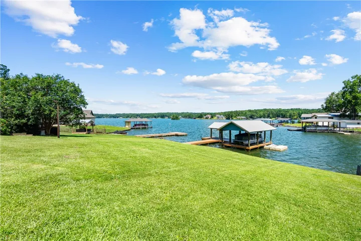 A tranquil lakefront property featuring private docks and lush green space, perfect for outdoor enjoyment.