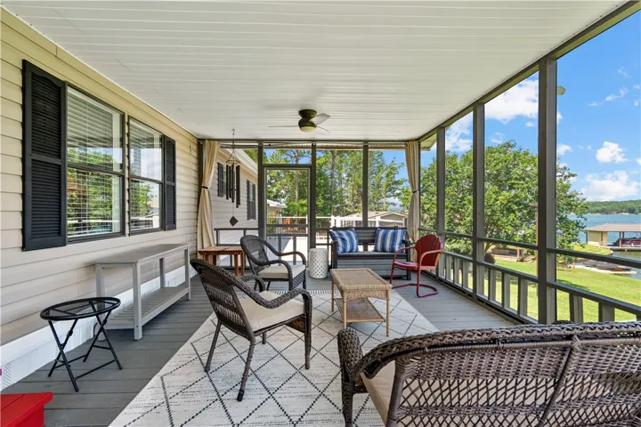 Enjoy tranquil water views and lakeside breezes from this screened-in porch with ample seating.