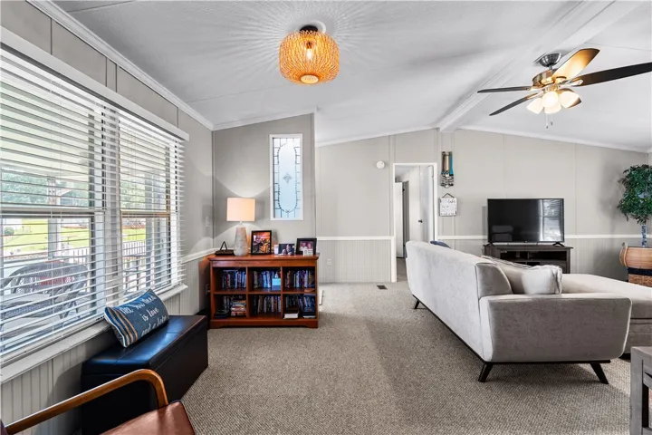 A comfortable living space boasts ample natural light and plush carpeting throughout.