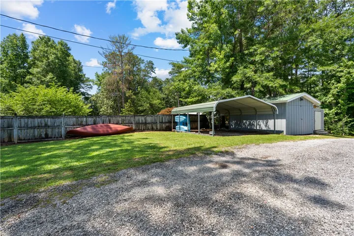 A detached shed and carport provide ample outdoor storage on this wooded property.